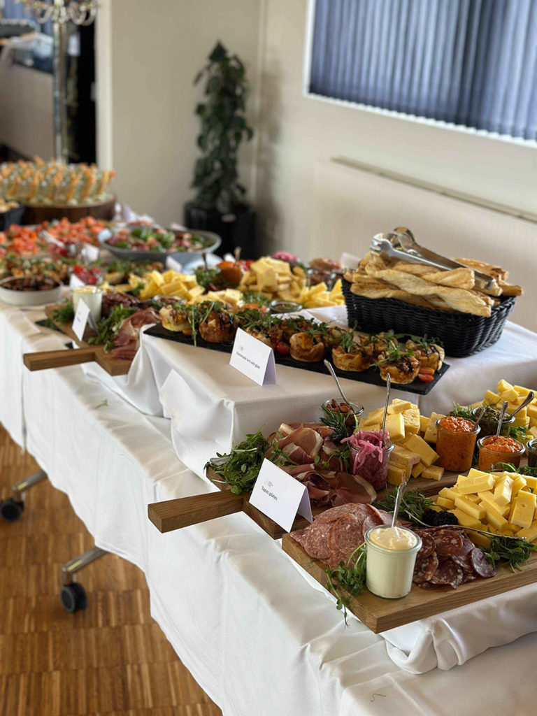 Indbydende tapasbuffet dækket op med charcuteri, oste, bruschetta og friskbagt brød – klar til gæsterne ved et elegant arrangement.