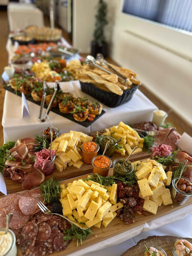 Indbydende tapasbuffet med ost, charcuteri, friskbagt brød og farverige dips – klar til at samle gæsterne omkring smag og hygge.
