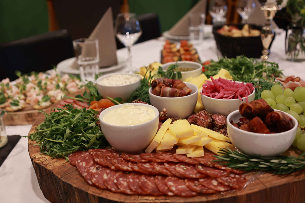 Et overdådigt tapasbræt fyldt med pølser, oste, frugt, grønt og små skåle med dips – anrettet med kærlighed til detaljen af Esbjerg Konference & Events eget køkken.