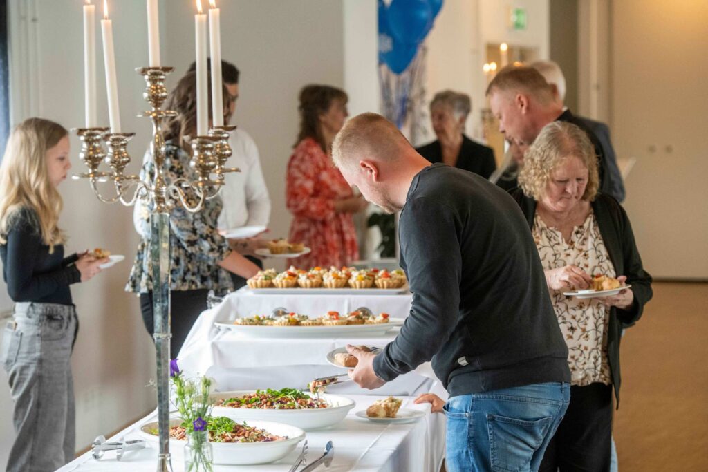 Gæster rundt om konfirmationsbuffet med forskellige forretter