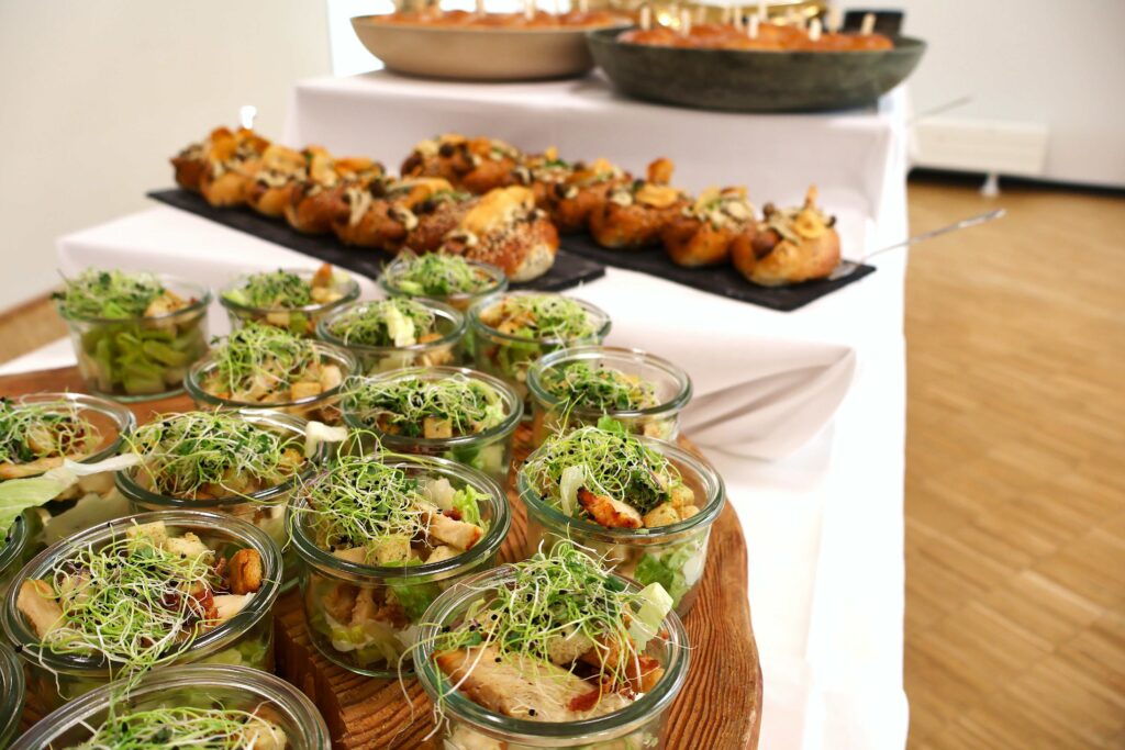 Forplejning til reception med små anretninger i glas og portioner på buffet