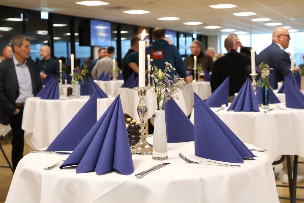 Reception i Claus Sørensen Loungen med højborde med blå servietter, levende lys og blomster