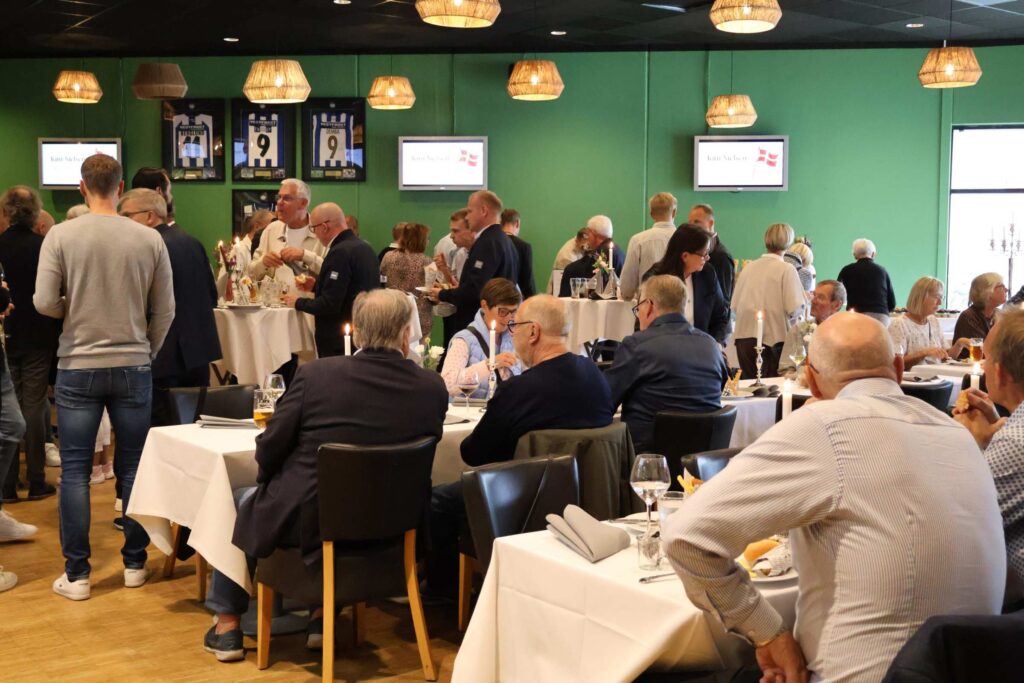 Gæster hygger og snakker sammen mens de spiser af receptionsbuffet lavet af Esbjerg Konference & Event i EfB Caféen.