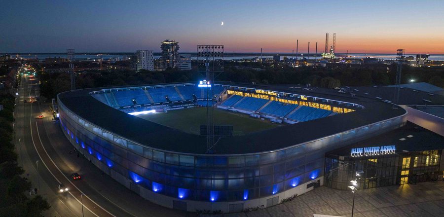 Dronebillede af Blue Water Arena med havnen og solnedgang i baggrunden
