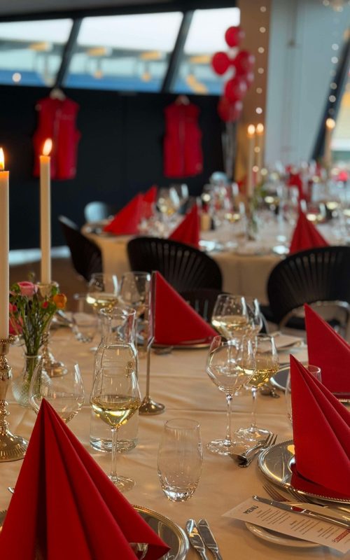 Røde servietter, levende lys og elegant opdækning sætter scenen for en festlig firmaaften med god mad, vin og hyggeligt samvær i Carlsberg Loungen.