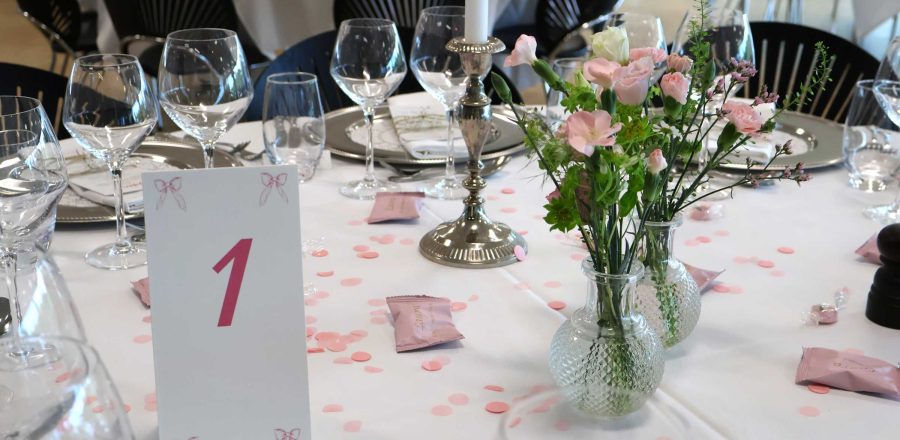 Opdækket bord til konfirmation med lyserrød og sløjfetema