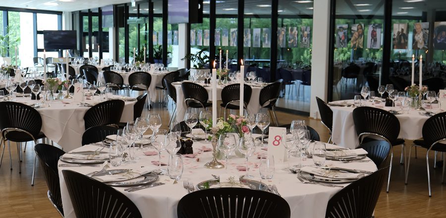 Smukt opdækkede borde til konfirmation i Claus Sørensen Loungen – elegant opdækning med hvide duge, sølvbestik og blomsterdekorationer.