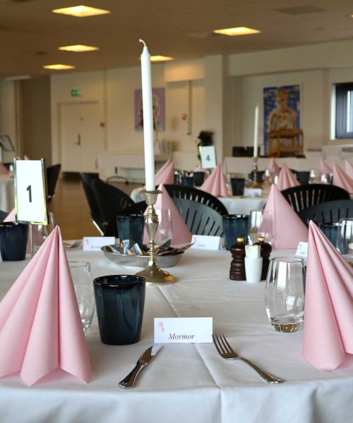 Lokale klar til barnedåb for pige med lyserrøde servietter og opstilling til brunchbuffet