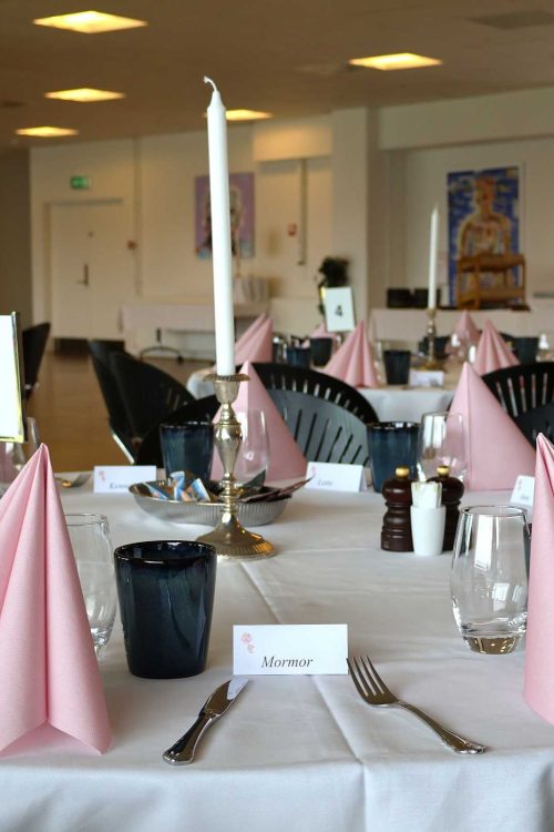 Lokale klar til barnedåb for pige med lyserrøde servietter og opstilling til brunchbuffet