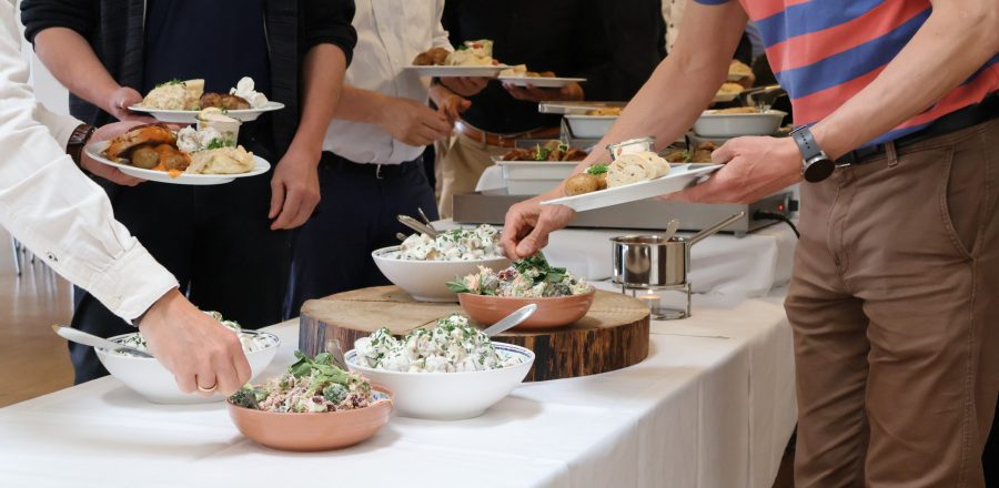 Gæster tager mad fra buffet med salater, kød og brød under frokostarrangement hos Esbjerg Konference & Event.