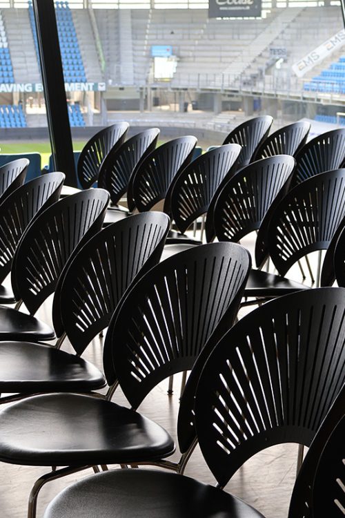 Stolerækker opstillet til oplæg eller konference med udsigt over tribunen på Blue Water Arena.