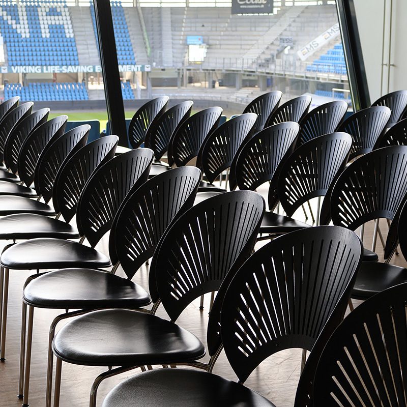 Stolerækker opstillet til oplæg eller konference med udsigt over tribunen på Blue Water Arena.