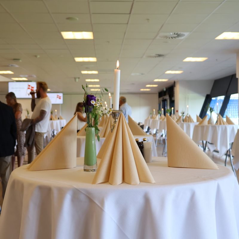 Opdækkede ståborde med hvide duge, servietter og levende lys til reception på Blue Water Arena i Carlsberg Loungen hos Esbjerg Konference & Event