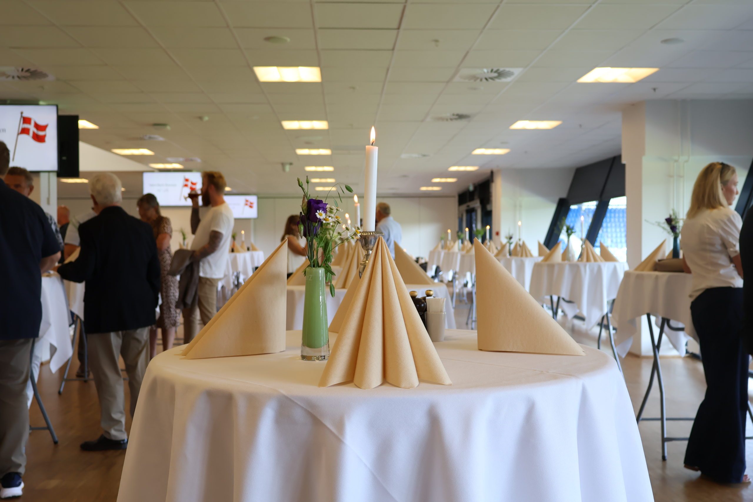 Opdækkede ståborde med hvide duge, servietter og levende lys til reception på Blue Water Arena i Carlsberg Loungen hos Esbjerg Konference & Event