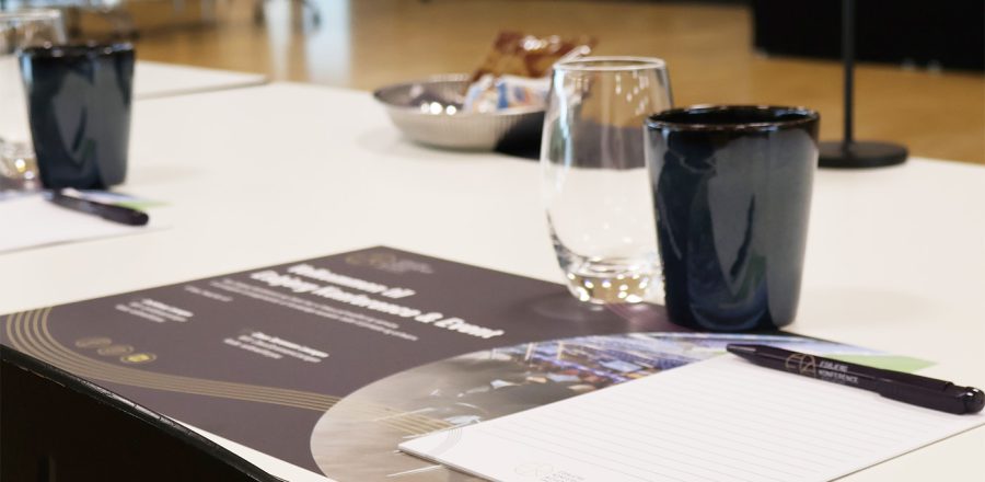 Lyst og indbydende mødelokale med borde dækket med glas, notesblokke og snacks klar til konference i Claus Sørensen Lounge hos Esbjerg Konference & Event.