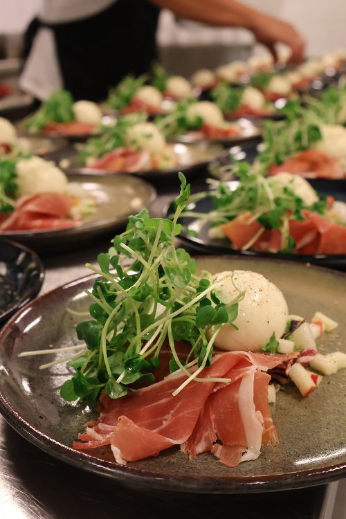Forret med Fanø skine, salat og burrata anrettet på tallerkener i køkkenet hos Esbjerg Konference & Event.