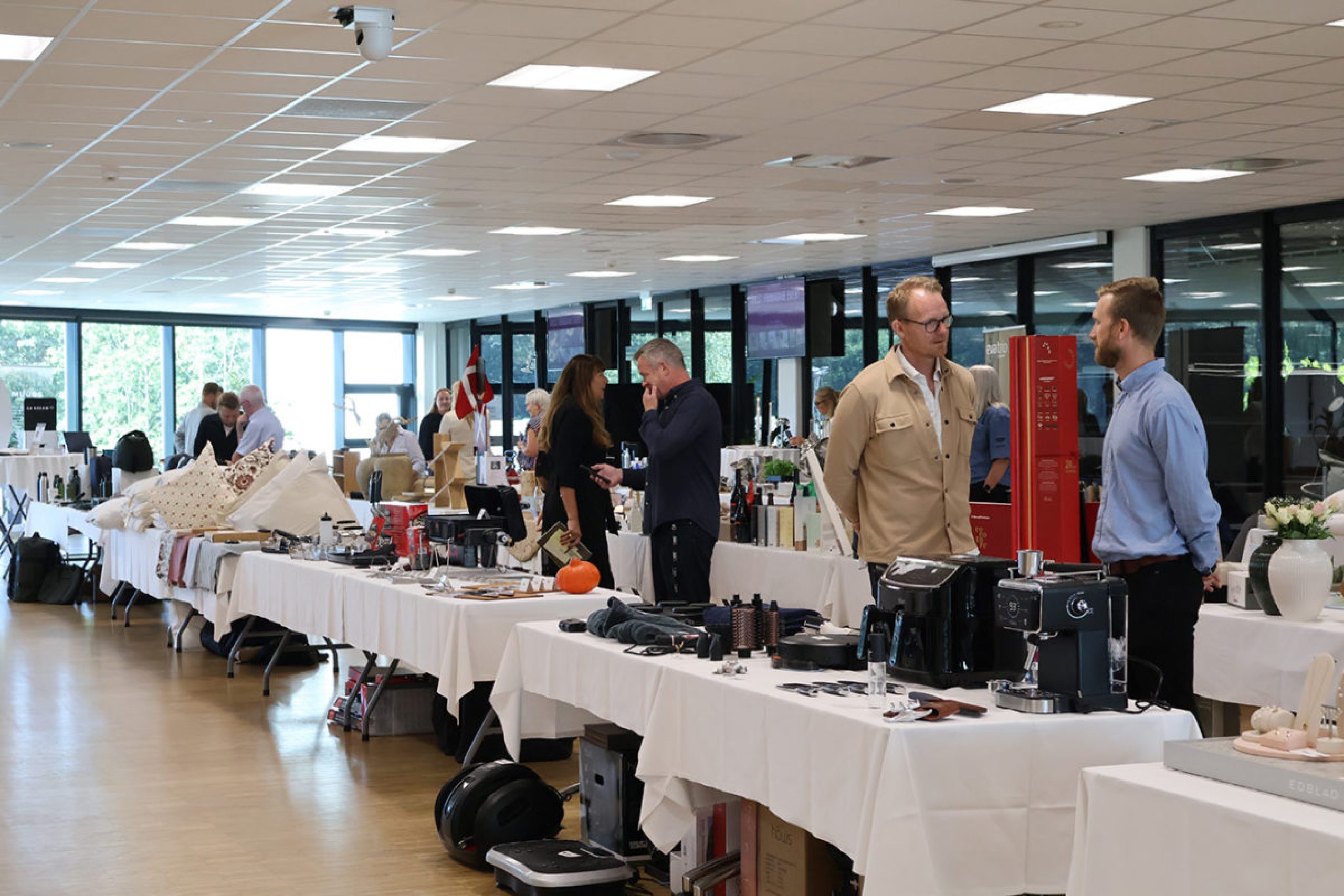 Udstillere og gæster i samtale ved stande med produkter under messearrangement hos Esbjerg Konference & Event.