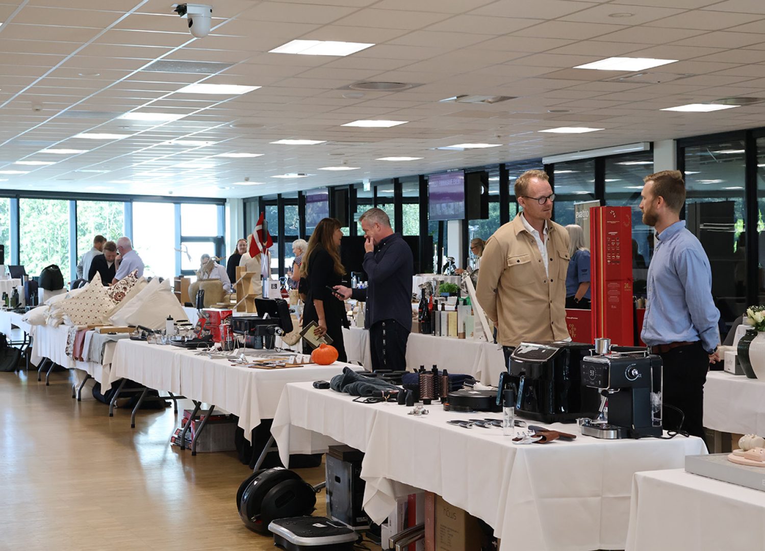 Udstillere og gæster i samtale ved stande med produkter under messearrangement hos Esbjerg Konference & Event.