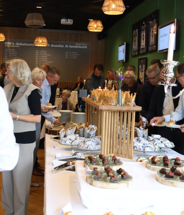 Gæster nyder af receptionsbuffet med små retter i alt sliders og hotdog til tacos og fish and chips fra i EfB Caféen