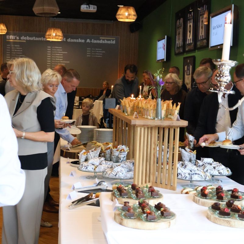 Gæster nyder af receptionsbuffet med små retter i alt sliders og hotdog til tacos og fish and chips fra i EfB Caféen