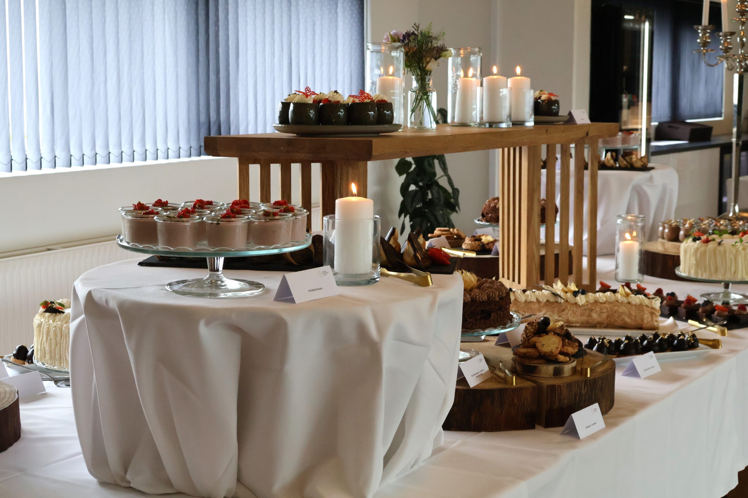 Kagebord med lækre desserter, friske bær og tændte lys til Den Store Kagedag hos Esbjerg Konference & Event.