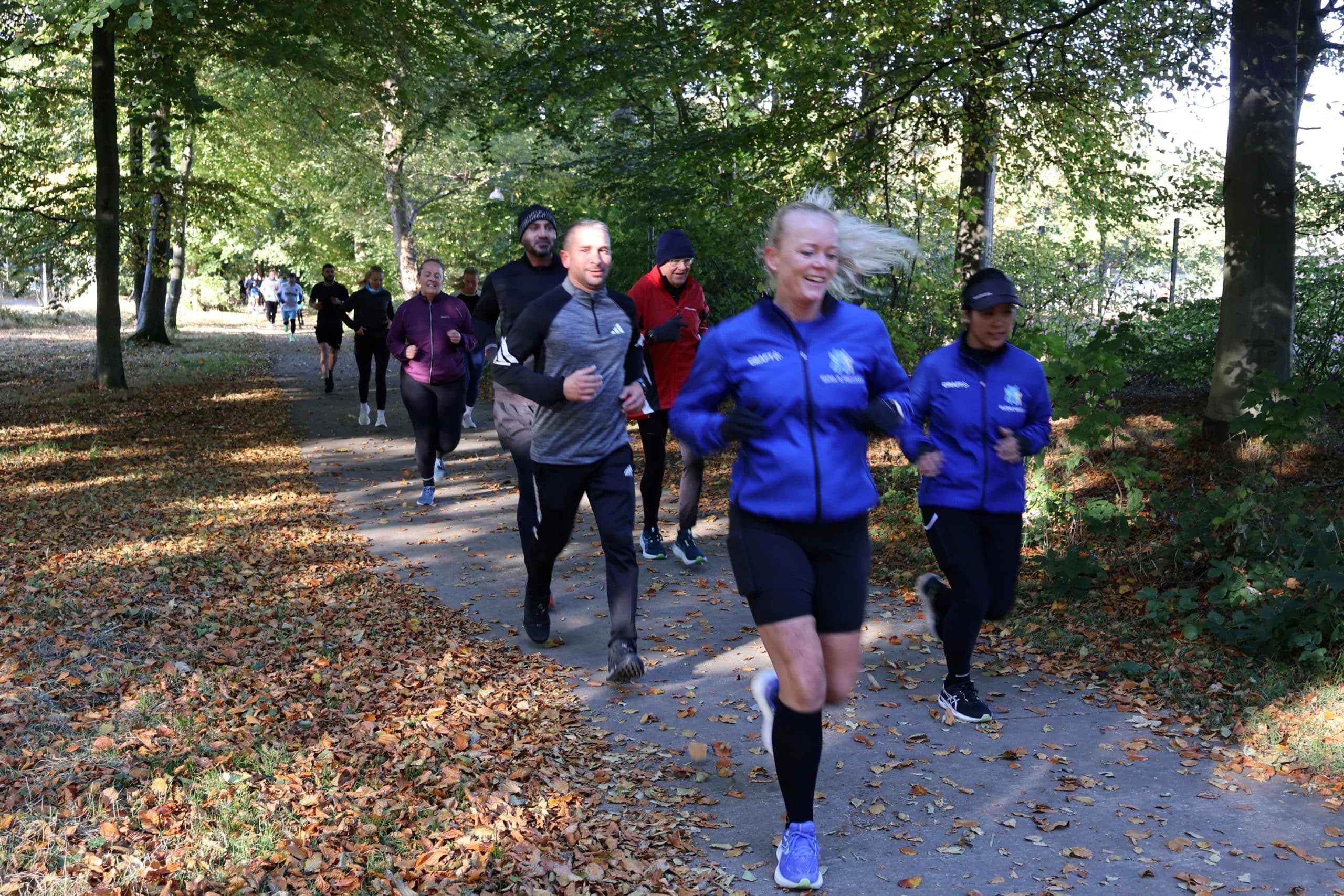 Glade mennesker løber i skov til social run hos Esbjerg Konference & Event