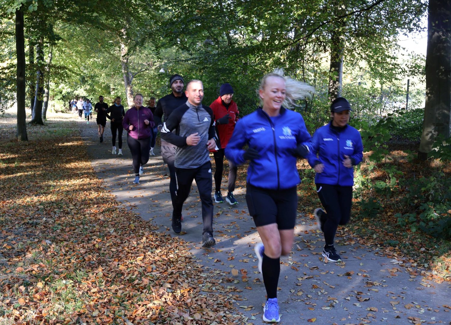Glade mennesker løber i skov til social run hos Esbjerg Konference & Event