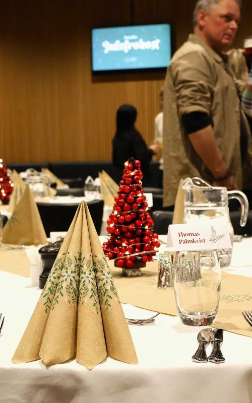 Julefrokost i EfB Caféen med opdækkede borde og røde juletræer