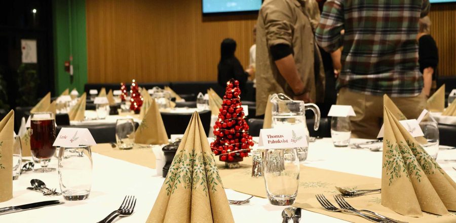 Julefrokost i EfB Caféen med opdækkede borde og røde juletræer