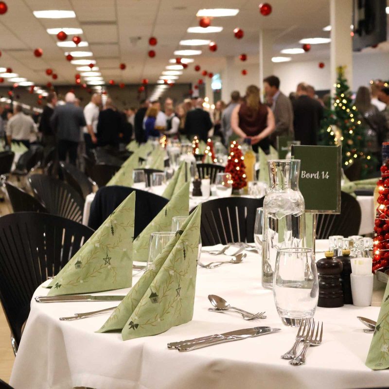 Julefrokost i eget lokale i Claus Sørensen Loungen pyntet med røde julekugler i loftet og dækket borde klar til julefrokost