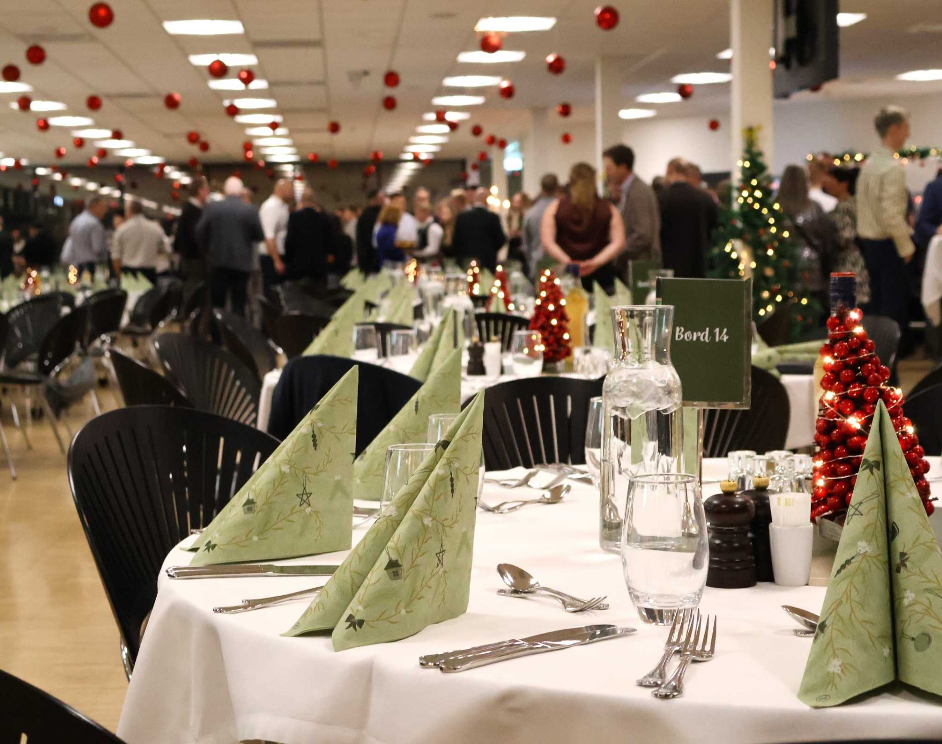 Julefrokost i eget lokale i Claus Sørensen Loungen pyntet med røde julekugler i loftet og dækket borde klar til julefrokost