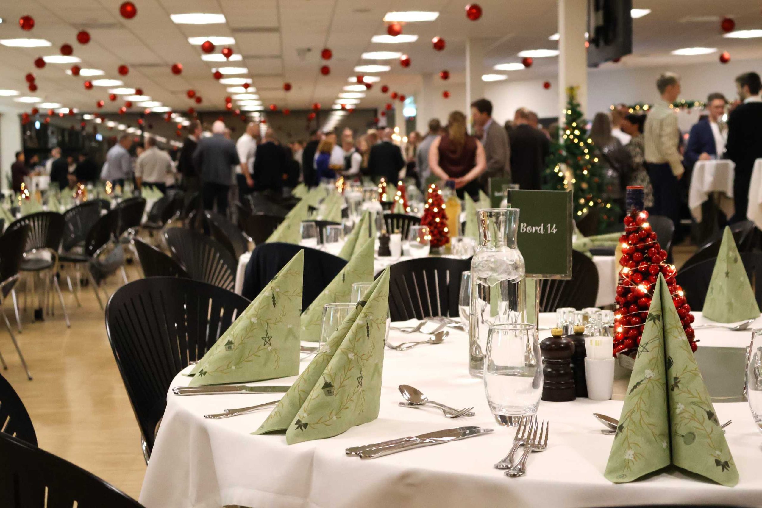 Julefrokost i eget lokale i Claus Sørensen Loungen pyntet med røde julekugler i loftet og dækket borde klar til julefrokost
