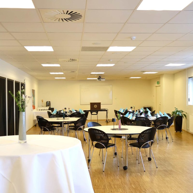 Skylounge 2 på Blue Water Arena dækket op til møde med lyseblå servietter, blomster og middag