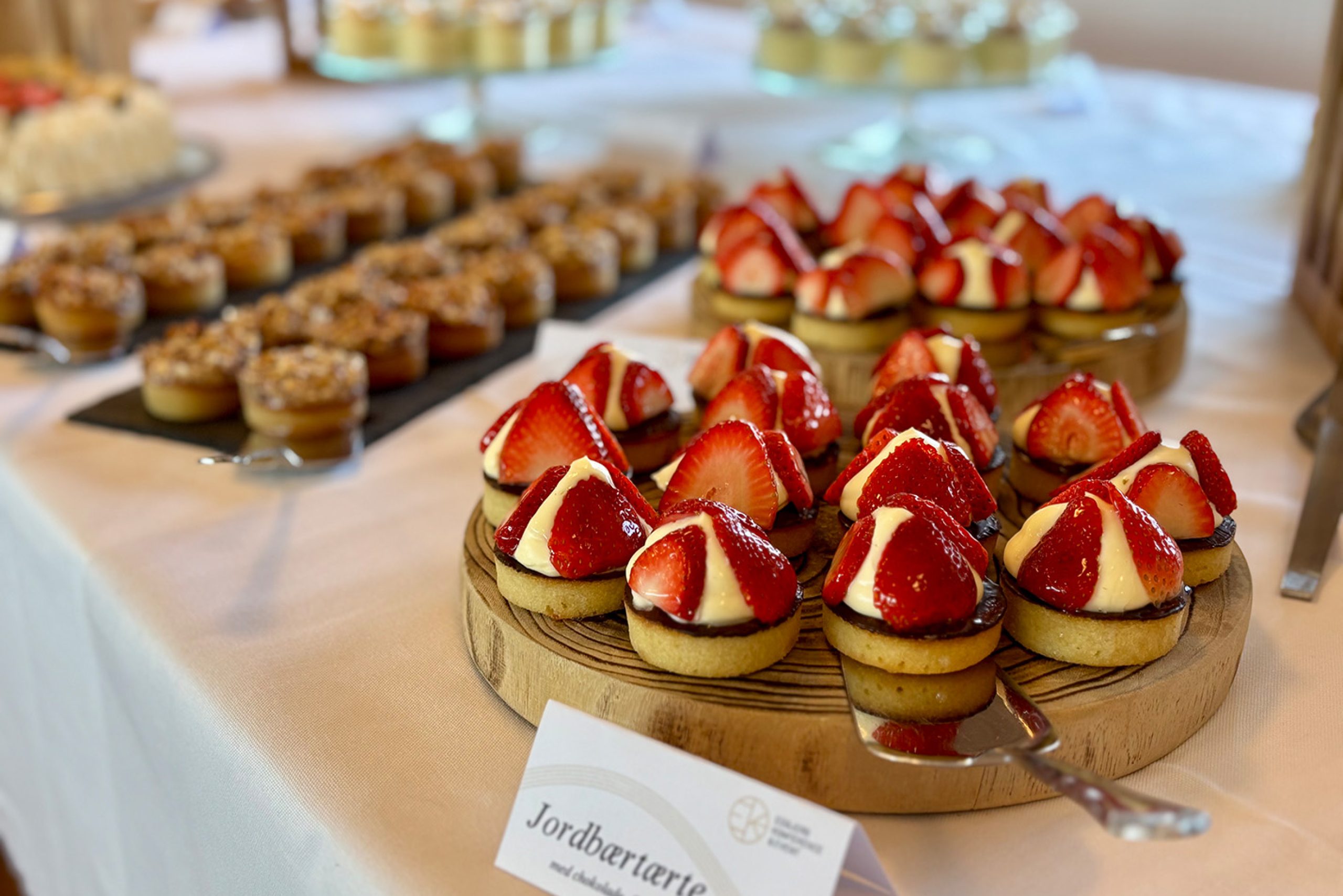 Jordbærtærter med chokolade og vaniljecreme anrettet på træfade ved Den Store Kagedag.