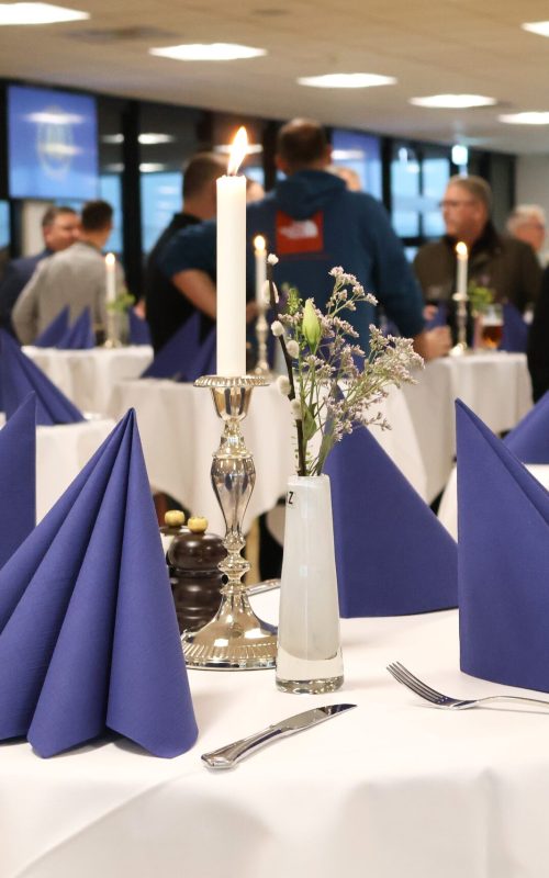 Reception i Claus Sørensen Loungen med højborde med blå servietter, levende lys og blomster