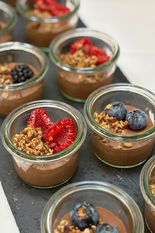Små portionsglas med chokolademousse pyntet med friske bær og sprød granola – lavet af husets egen konditor.
