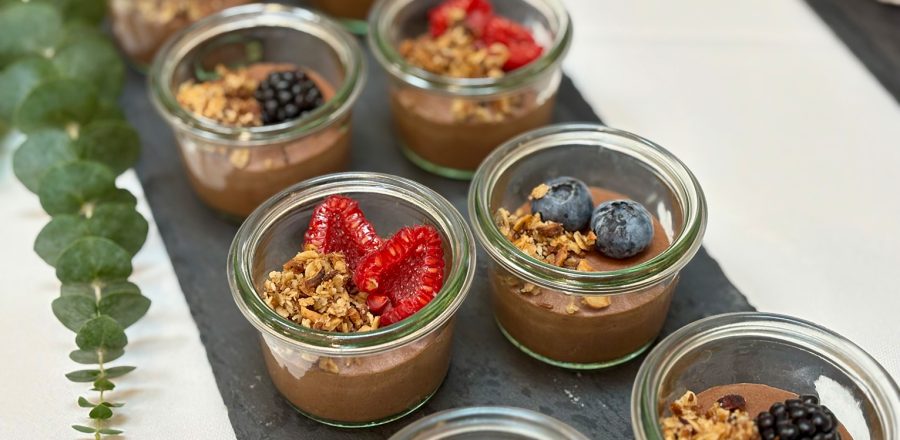 Små portionsglas med chokolademousse pyntet med friske bær og sprød granola – lavet af husets egen konditor.