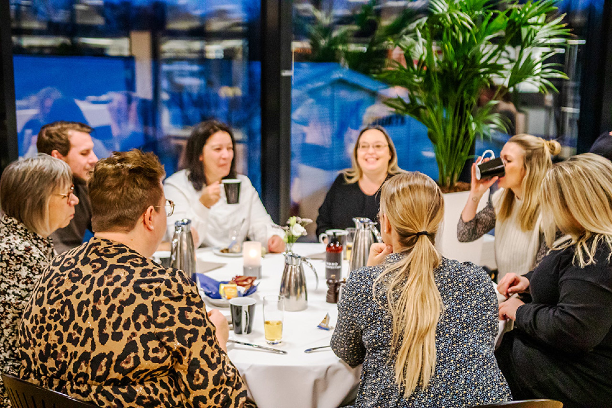 Gæster nyder kaffe og samtale omkring et opdækket bord i hyggelige omgivelser i Claus Sørensen Lounge hos Esbjerg Konference & Event.