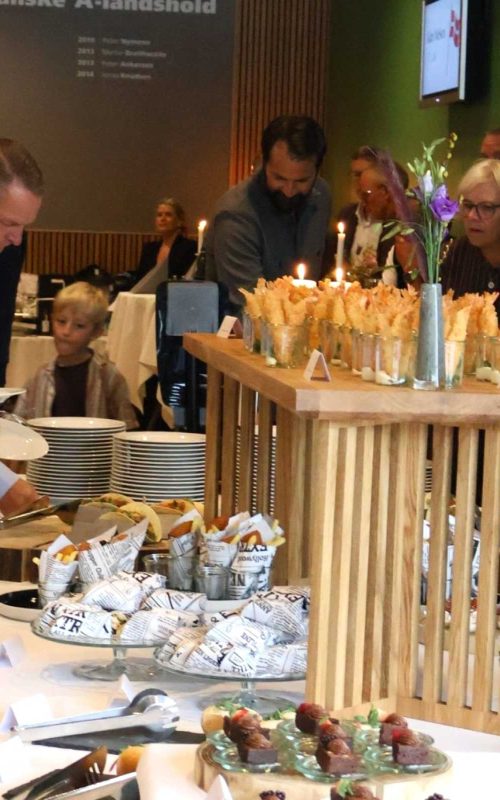 Gæster nyder af receptionsbuffet med små retter i alt sliders og hotdog til tacos og fish and chips fra i EfB Caféen