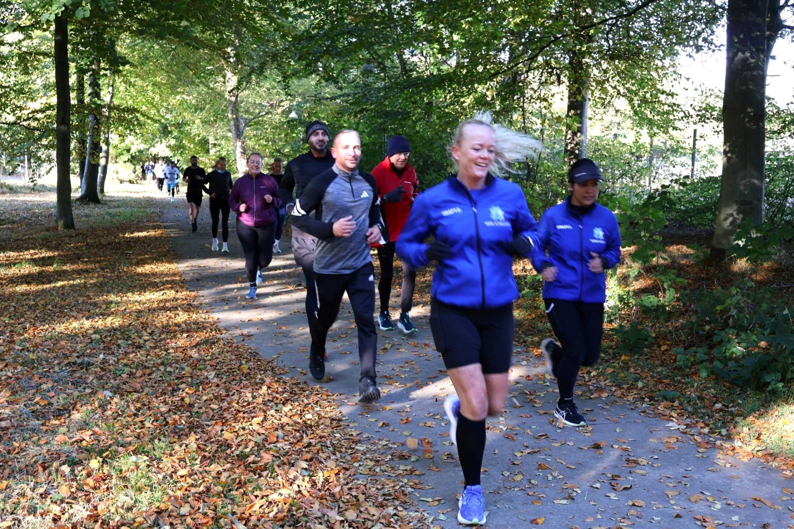 Glade mennesker løber i skov til social run hos Esbjerg Konference & Event