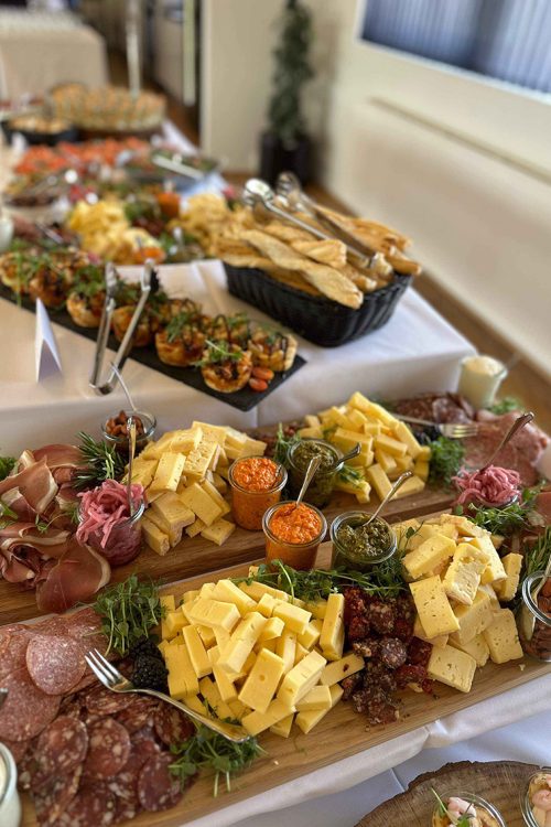 Indbydende tapasbuffet med ost, charcuteri, friskbagt brød og farverige dips – klar til at samle gæsterne omkring smag og hygge.