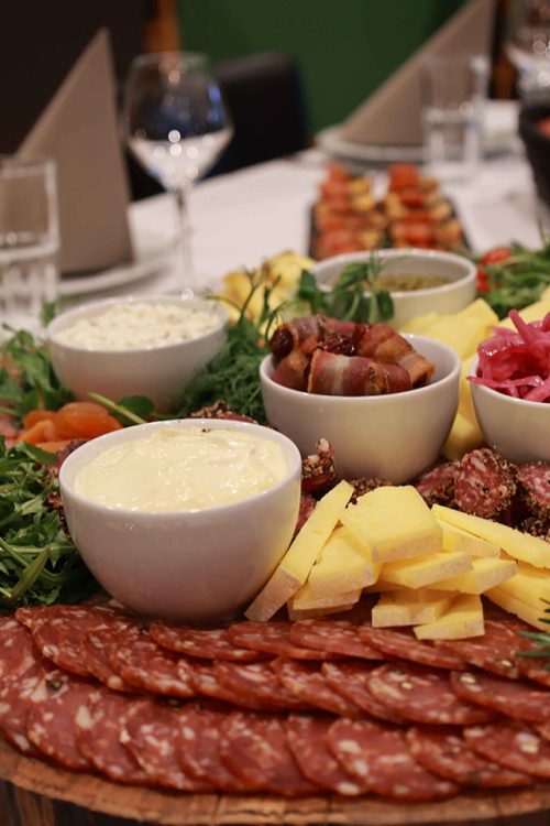 Et overdådigt tapasbræt fyldt med pølser, oste, frugt, grønt og små skåle med dips – anrettet med kærlighed til detaljen af Esbjerg Konference & Events eget køkken.